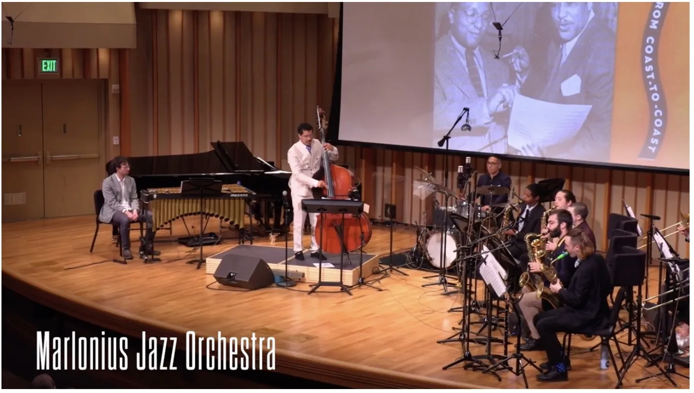The Marlonius Jazz Orchestra performs with Marlon Martinez at the bass and Billy Strayhorn’s portrait projected behind them.